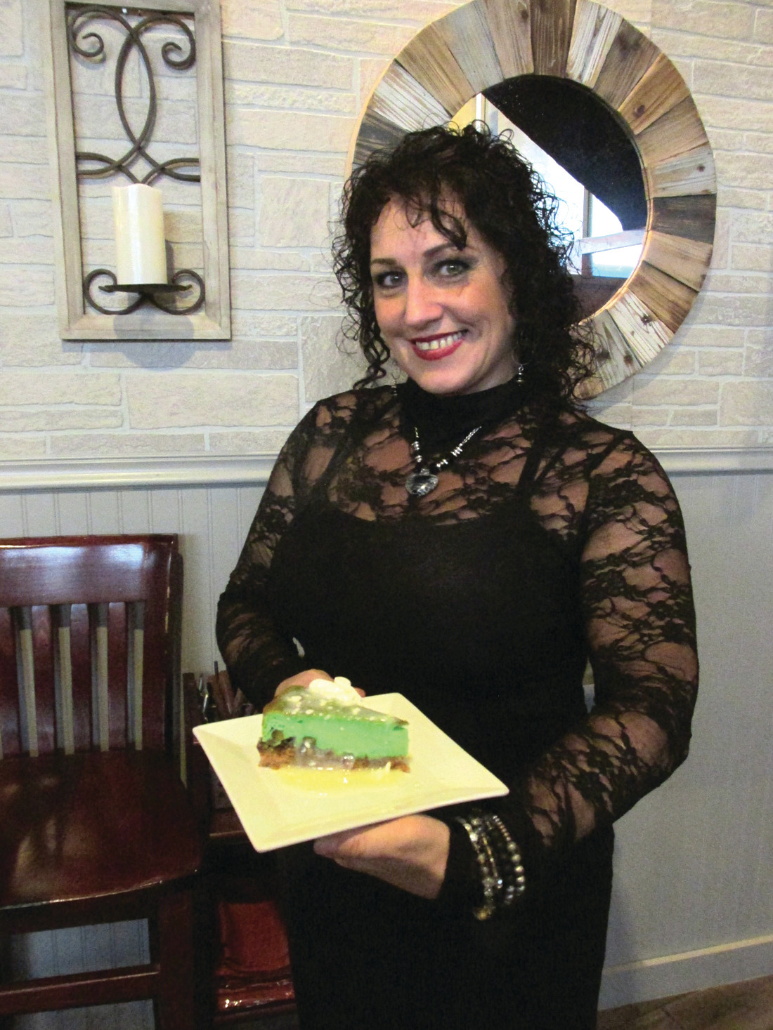 CLEVER CREATION: Susie Marshall, a super staffer at The Ave Restaurant Bar & Grill, holds a serving of Pistachio Cheesecake, one of Chef-Owner Jennifer Lombardo’s creations.